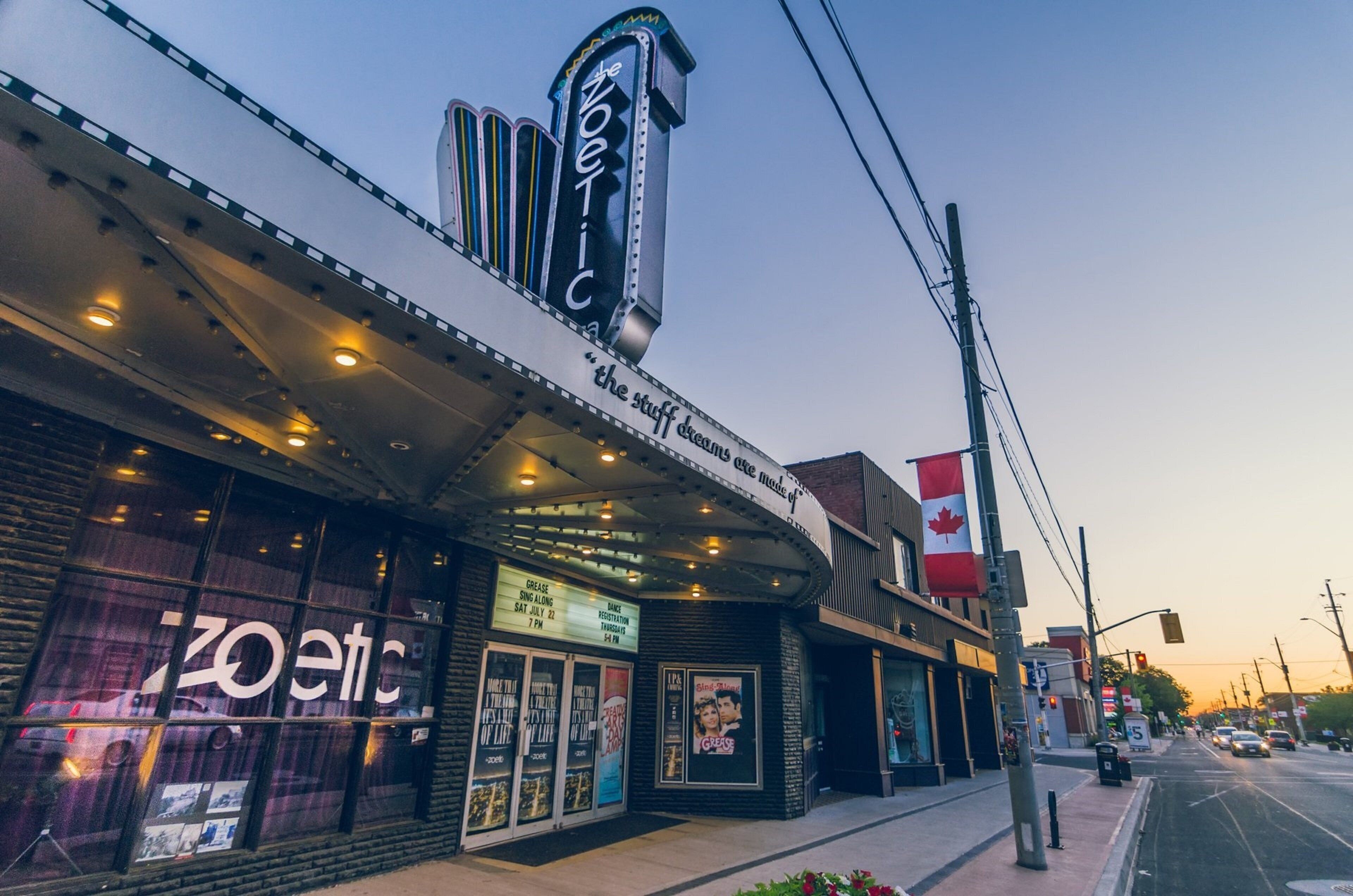 A theater with a marquee reading "The Zoetic" and a sign stating "the stuff dreams are made of."