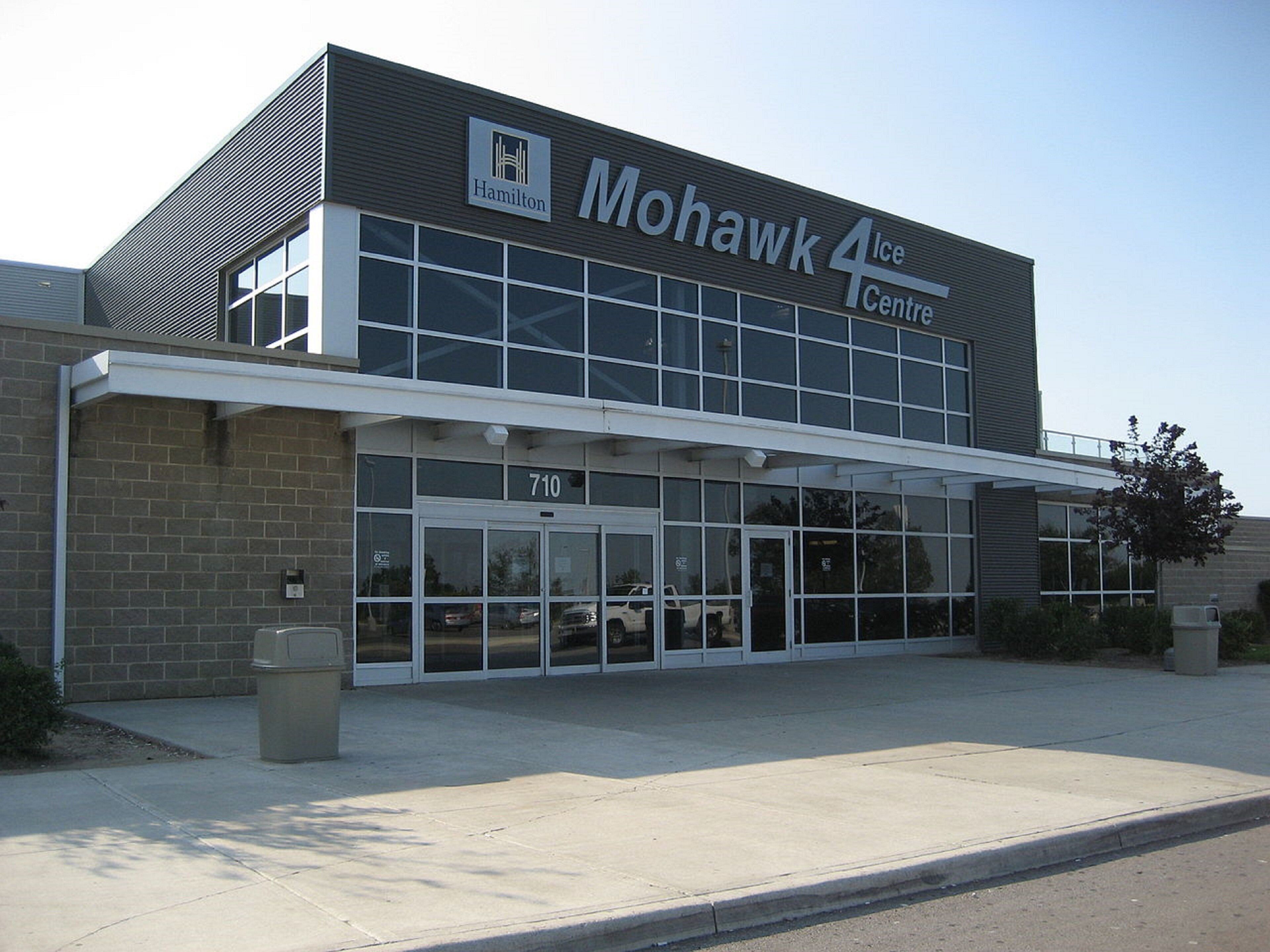 Das Mohawk Ice Centre, ein Gebäude mit großem Glasvordereingang, Ziegelverkleidung und einem Schild über dem Eingang.