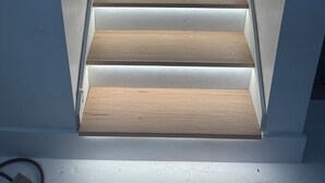 Una escalera moderna con escalones de madera y paredes blancas.