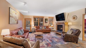 A living room with leather sofas, a fireplace, and a television. - Sm8194-3 (Keystone)