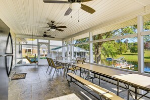 A covered patio with tables and chairs, a view of a lake, and ceiling fans. - Walk to Marina! Prosperity Home w/ Screened Porch (Prosperity)