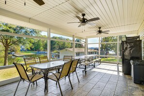 A covered patio with a table and chairs, a ceiling fan, and a view of a lake and houses. - Walk to Marina! Prosperity Home w/ Screened Porch (Prosperity)