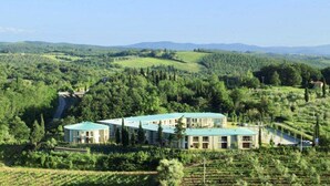 A hotel with multiple buildings surrounded by lush greenery and rolling hills. - Chianti Village Studio Apartment (Barberino Tavernelle)