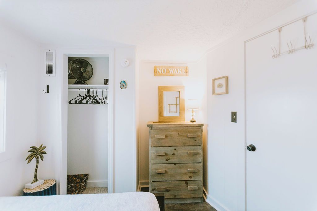 Un dormitorio con cama, cómoda, armario y un letrero que dice 'NO WAKE'.