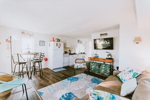 A compact living space with a kitchenette, dining area, and seating area. - Coastal Dunes 1: Oceanfront Cottage in Nags Head, Great Views! (Nags Head)
