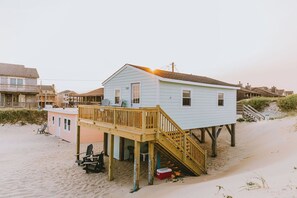 A beach house with a wooden deck and a staircase leading to the main building. - Coastal Dunes 1: Oceanfront Cottage in Nags Head, Great Views! (Nags Head)
