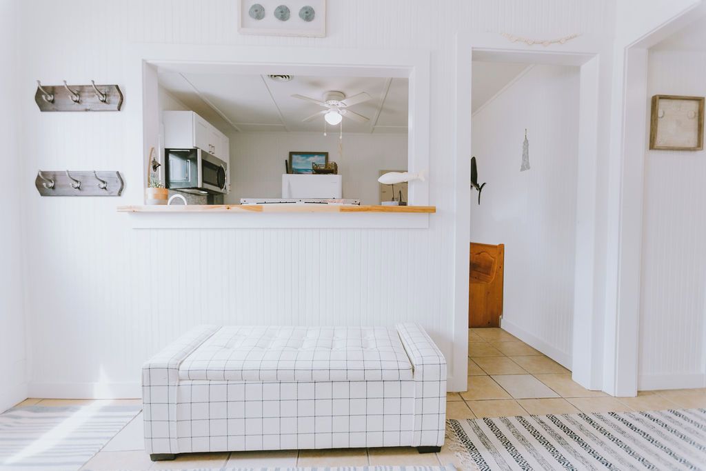 Un espacio habitable compacto con kitchenette, ventilador de techo y un pequeño rincón de descanso.