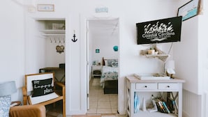 Een gezellige kamer met een bed, een bureau en een televisie waarop 'Coastal Carolina Vacations and Sales' staat.