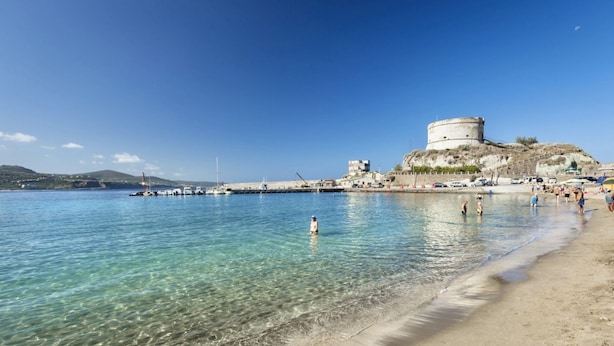 A coastal beach with clear water, a sandy shore, and a historic fort on a hill. - Nice apartment on the ground floor with sea view of about 45 m2 equipped with air conditioning and wi fi connection, composed of a living room with equipped kitchenette, fridge and flat-screen television.It can be on one level or with a mezzanineA double (Bosa Marina)