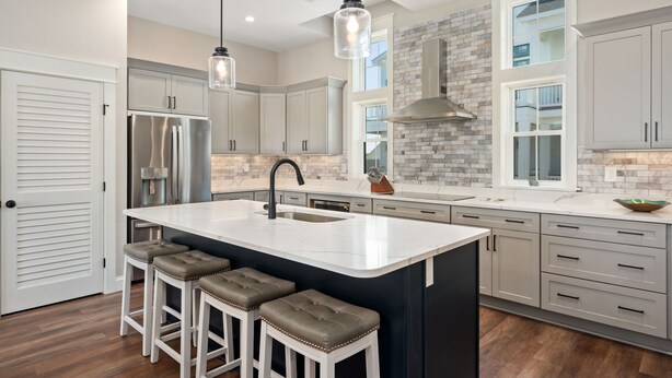 A modern kitchen with a large island, stainless steel appliances, and a stone backsplash. - Casita Miramar!: Semi-Oceanfront, Newly-Built Townhome, Community Pool! (Kill Devil Hills)