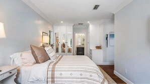 Une chambre à coucher avec un grand lit, une table de chevet, une commode et un miroir.