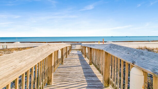 A wooden boardwalk leading to a beach with a clear sky. - Beachside @ Seaside Beach & Racquet 2BR Condo • Sleeps 6 • Pools, Tennis & Beach Access (Orange Beach)