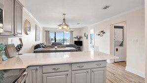 A modern kitchen with a large island, built-in appliances, and a view to the living area. - Beachside @ Seaside Beach & Racquet 2BR Condo • Sleeps 6 • Pools, Tennis & Beach Access (Orange Beach)