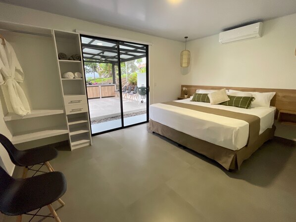 A bedroom with a bed, a desk, and a wardrobe.