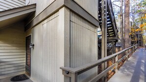 A wooden exterior with a metal railing and a door.
