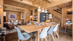 Een houten interieur met een eettafel, stoelen en een keukenhoek.