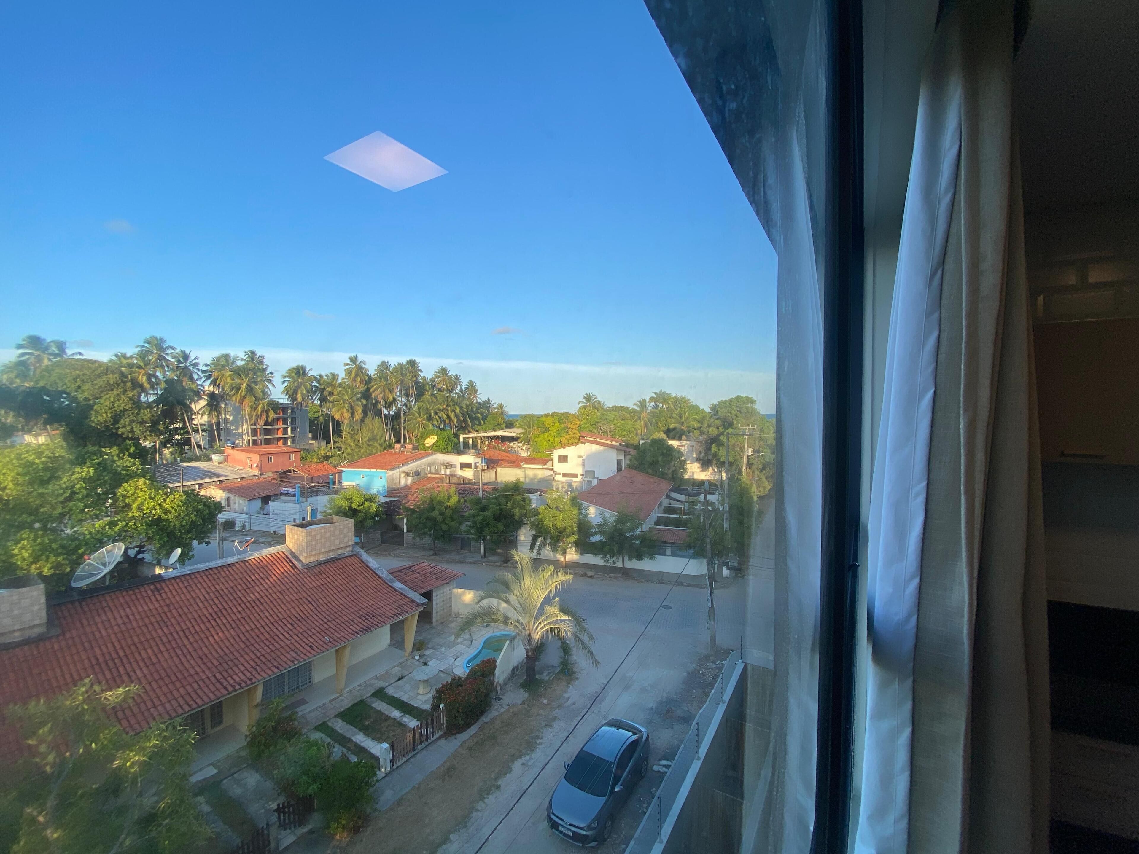 A residential area with houses, a road, and a car.