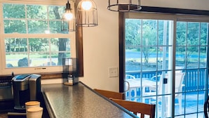 A kitchen with a granite countertop, coffee maker, and hanging pendant lights. - Charming Chalet at Pocono Ridge (Albrightsville)