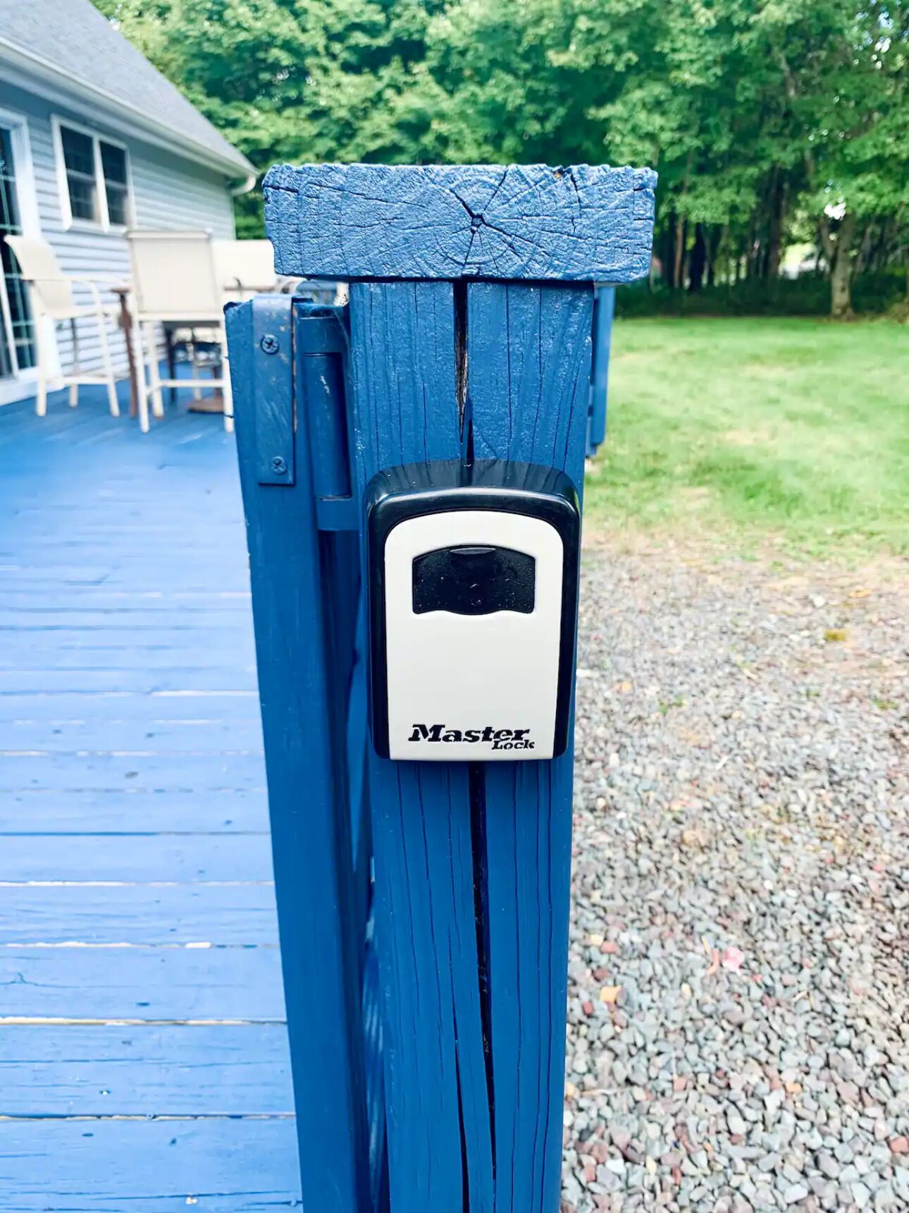 Un poste de madera azul con un candado Master Lock.