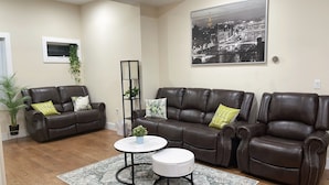 A living room with two brown leather sofas, a white coffee table, and a patterned rug.