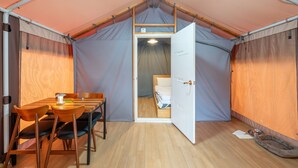 A compact room with a wooden table and chairs, a bed, and a small dog bed. - Gapeyong Fourseason Pet Glamping Caravan (Gapyeong)