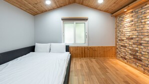 A bedroom with a bed, wooden ceiling, brick wall, and a window with blinds. - Gapeyong Fourseason Pet Glamping Caravan (Gapyeong)