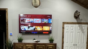 A living room with a mounted TV, wooden cabinet, and a unique coffee table.