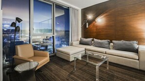 Una sala de estar moderna con un amplio ventanal, un sofá, un sillón y una mesa de centro.
