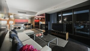 A modern living room with a sofa, coffee table, TV, and a city view. - SVS: 1BD Strip View | Jetted Tub | Full Kitchen | Sleeps 4 | Palms Place (Las Vegas)