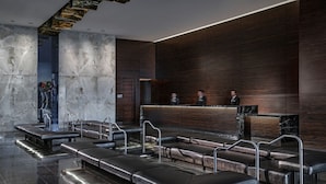 A modern lobby with a reception desk, leather seating, and a marble wall. - SVS: 1BD Strip View | Jetted Tub | Full Kitchen | Sleeps 4 | Palms Place (Las Vegas)