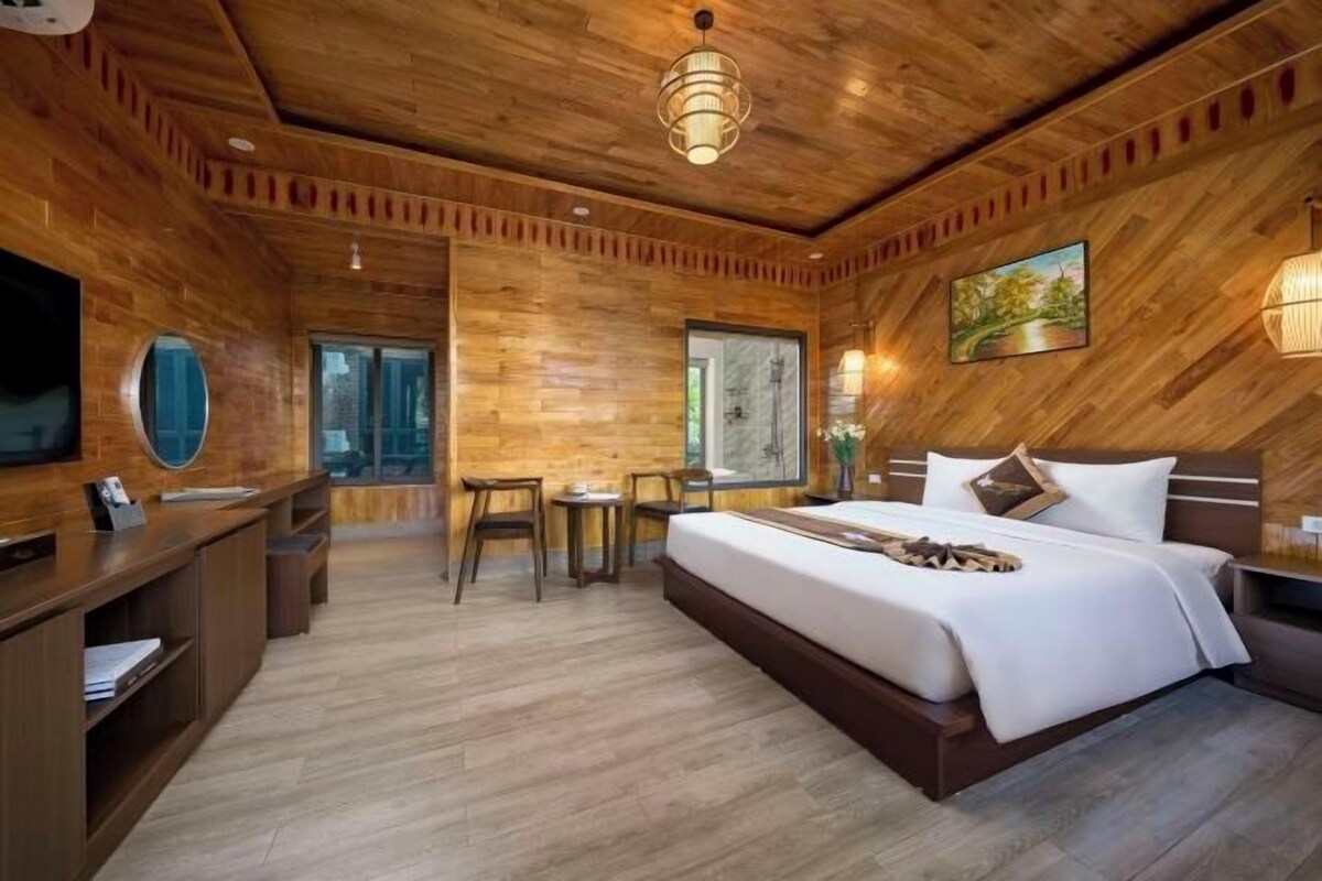 Ein schlafgemach im Holzstil mit Bett, Schreibtisch und Sitzecke.