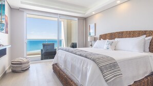 Een hotelkamer met een groot bed, uitzicht op zee en een balkon.