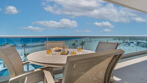 Enjoy a romantic meal for two on this oceanfront balcony with a round dining table and wicker chairs.