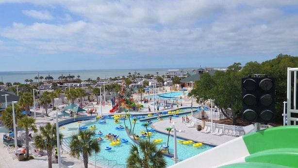 Een zwembadgedeelte van een resort met meerdere glijbanen en uitzicht op de oceaan.
