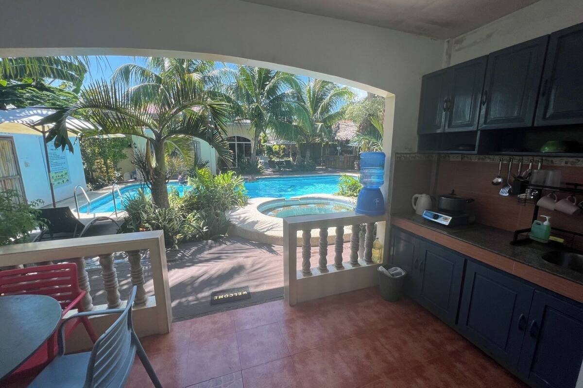 Une cuisine avec vue sur une piscine et des palmiers.