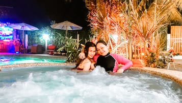 Una piscina al aire libre, sombrillas, sillones reclinables de piscina