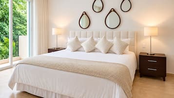 Habitación de hotel con una cama grande, dos mesitas de noche y vistas a zonas verdes por la ventana.