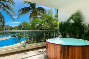 Un balcón con vista a una piscina y palmeras.