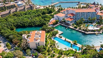 Un complejo turístico con varias edificaciones, una piscina central y un puerto deportivo.