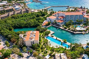 Un complexe hôtelier comprenant plusieurs bâtiments, une piscine centrale et un port de plaisance.