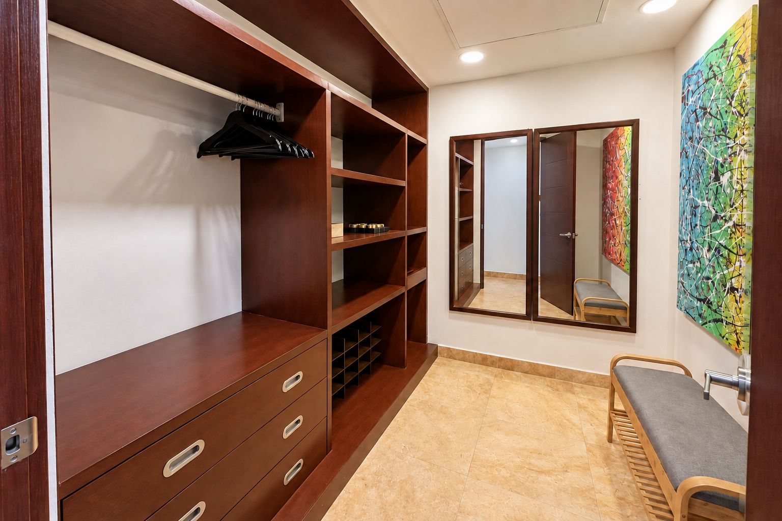 Un vestidor con estanterías de madera, un banco y un espejo.