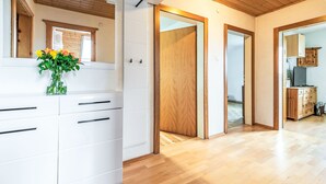 A modern kitchen with white cabinets, a wooden ceiling, and a wooden floor. - Ferienwohnung Grimmingblick by Interhome (Öblarn)