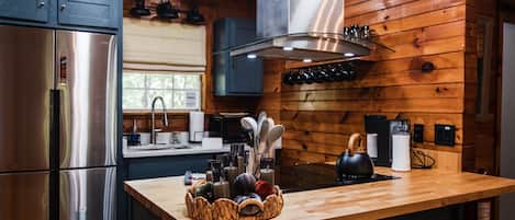 Una cocina moderna con paredes de madera, electrodomésticos de acero inoxidable y una isla central con frutero.