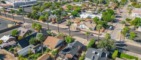 An aerial view of a residential area with houses, streets, and a distant city skyline.