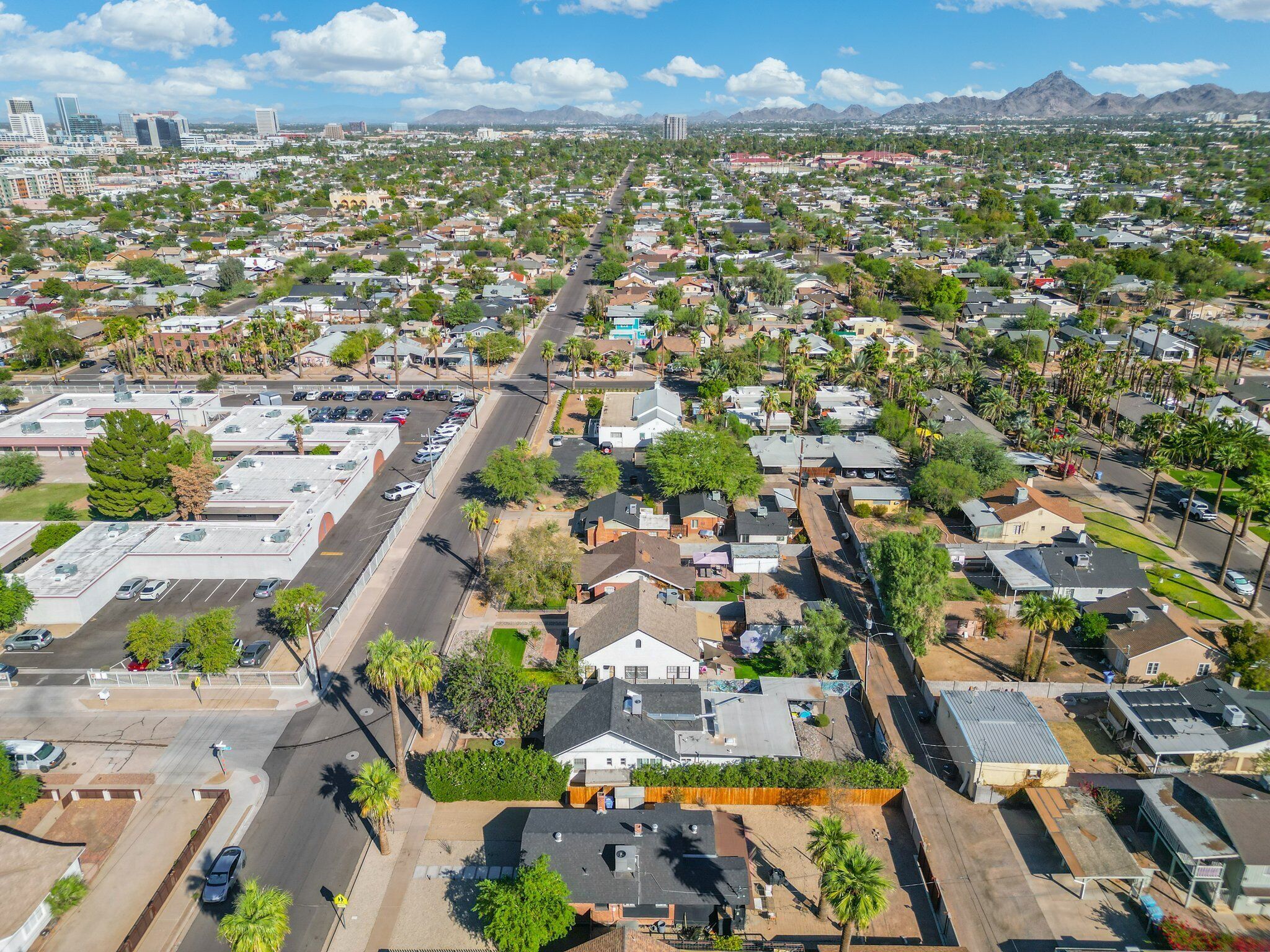 Vista aérea de una zona residencial con casas, calles y una cadena montañosa al fondo.