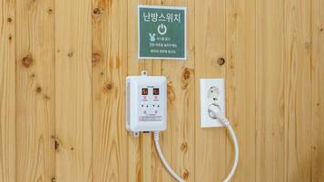 A wooden wall with a power outlet and a control unit.
