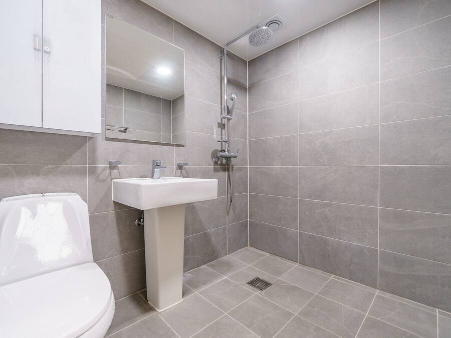 A modern bathroom with a toilet, sink, and shower.
