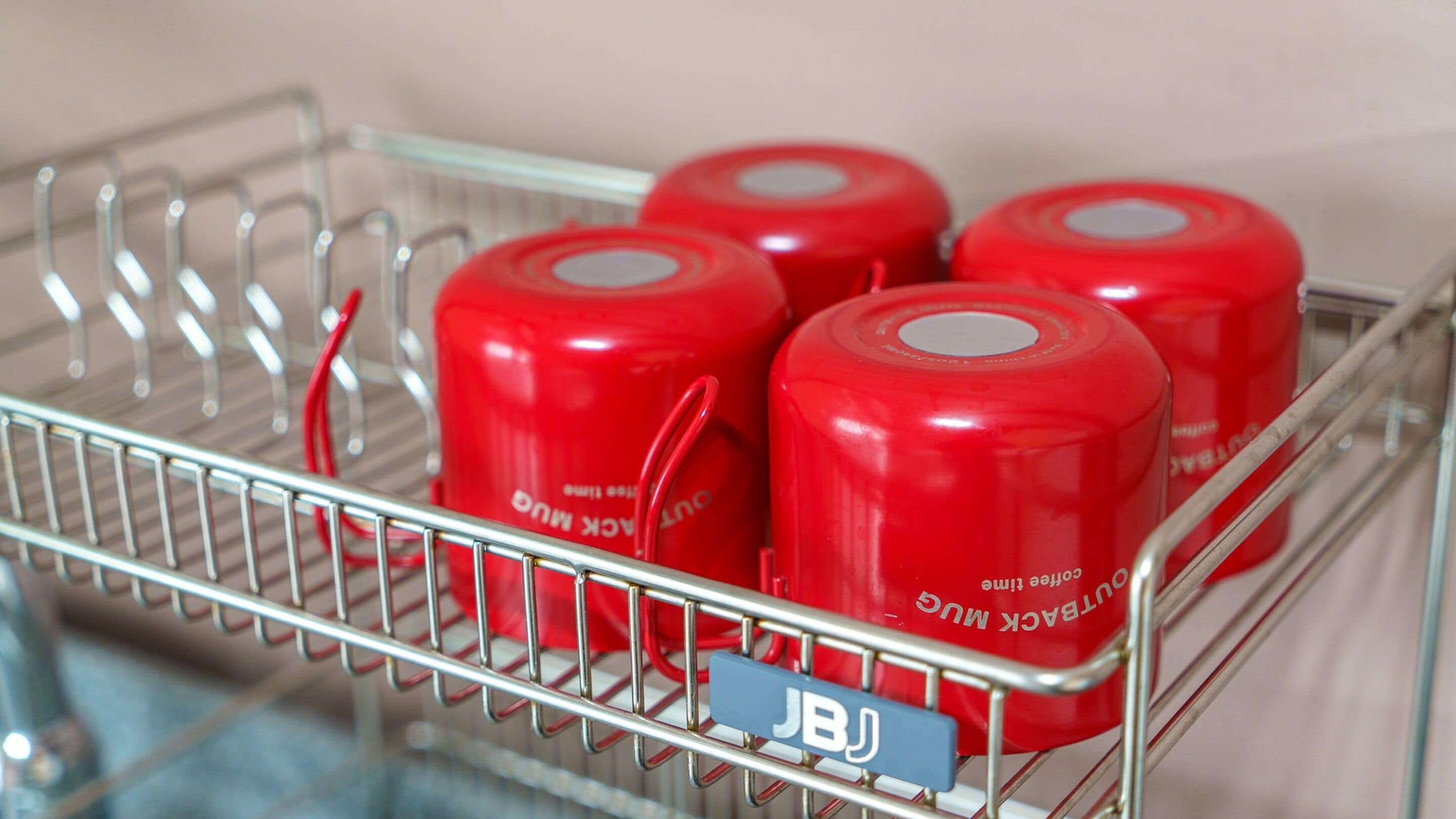 A shopping cart with four red containers labeled "DUNWARK MUG" and a blue tag with "JBJ".