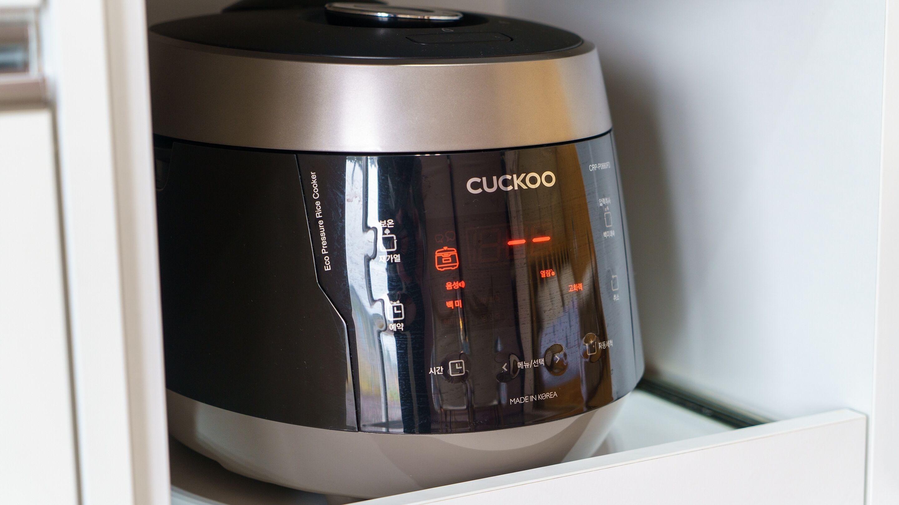 Een Cuckoo rijstkoker met een digitaal bedieningspaneel, een snelkookpanfunctie en een 'Made in Korea'-aanduiding.