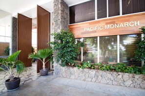 A building facade with a sign reading "PACIFIC MONARCH".